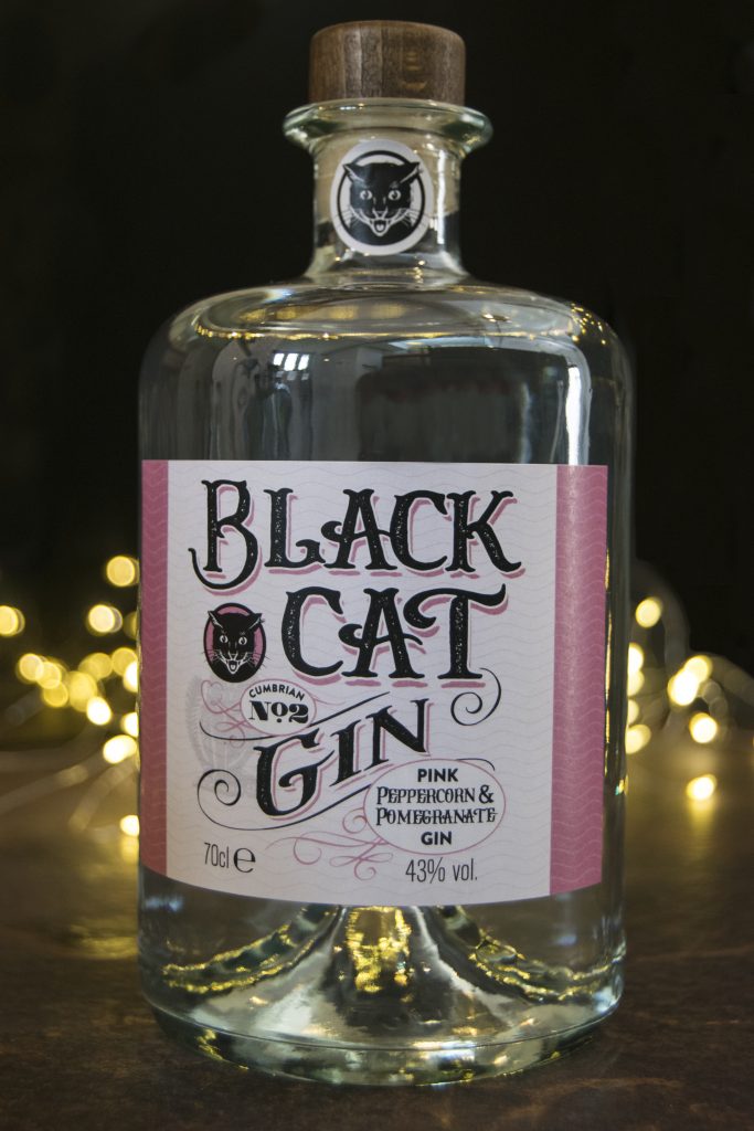 Bottle of Black Cat Fruity Gin Cumbrian No 2 with sparkly lights behind.