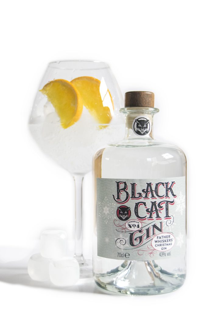 A glass of Black Cat Father Whiskers Christmas gin Cumbrian No 4 with ice and orange wedges